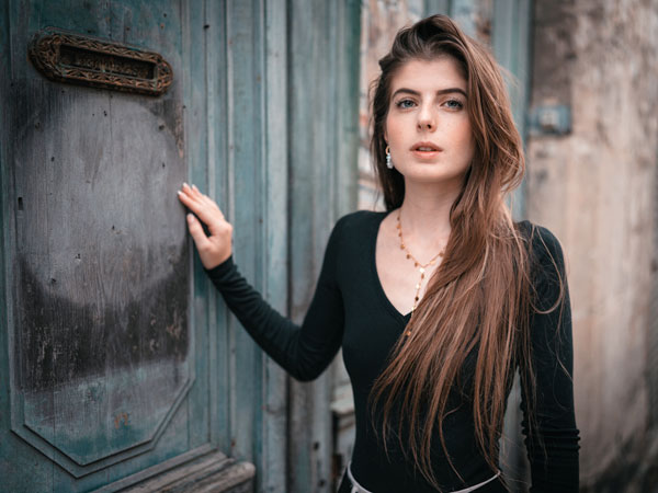 photographie d'une femme à Laon en France devant une porte de maison médiévale carousel desktop